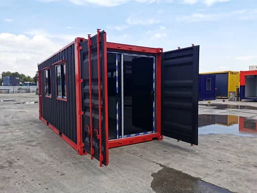 Black shipping container office with red trim, side windows and the end doors swung open to show a glazed end.
